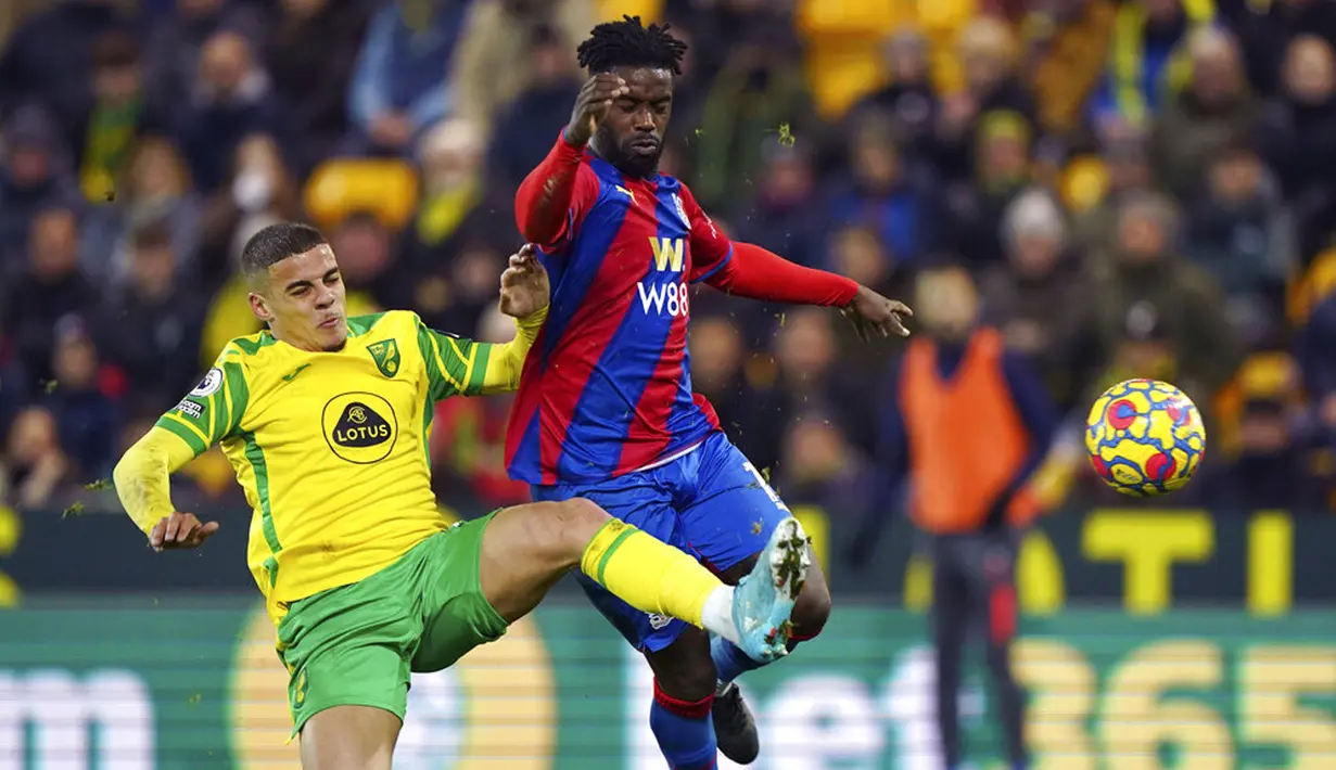 Pemain Norwich City Max Aarons (kiri) berebut bola dengan pemain Crystal Palace Jeffrey Schlupp pada pertandingan sepak bola Liga Inggris di Carrow Road, Norwich, Inggris, 9 Februari 2022. Pertandingan berakhir imbang 1-1. (Joe Giddens/PA via AP)