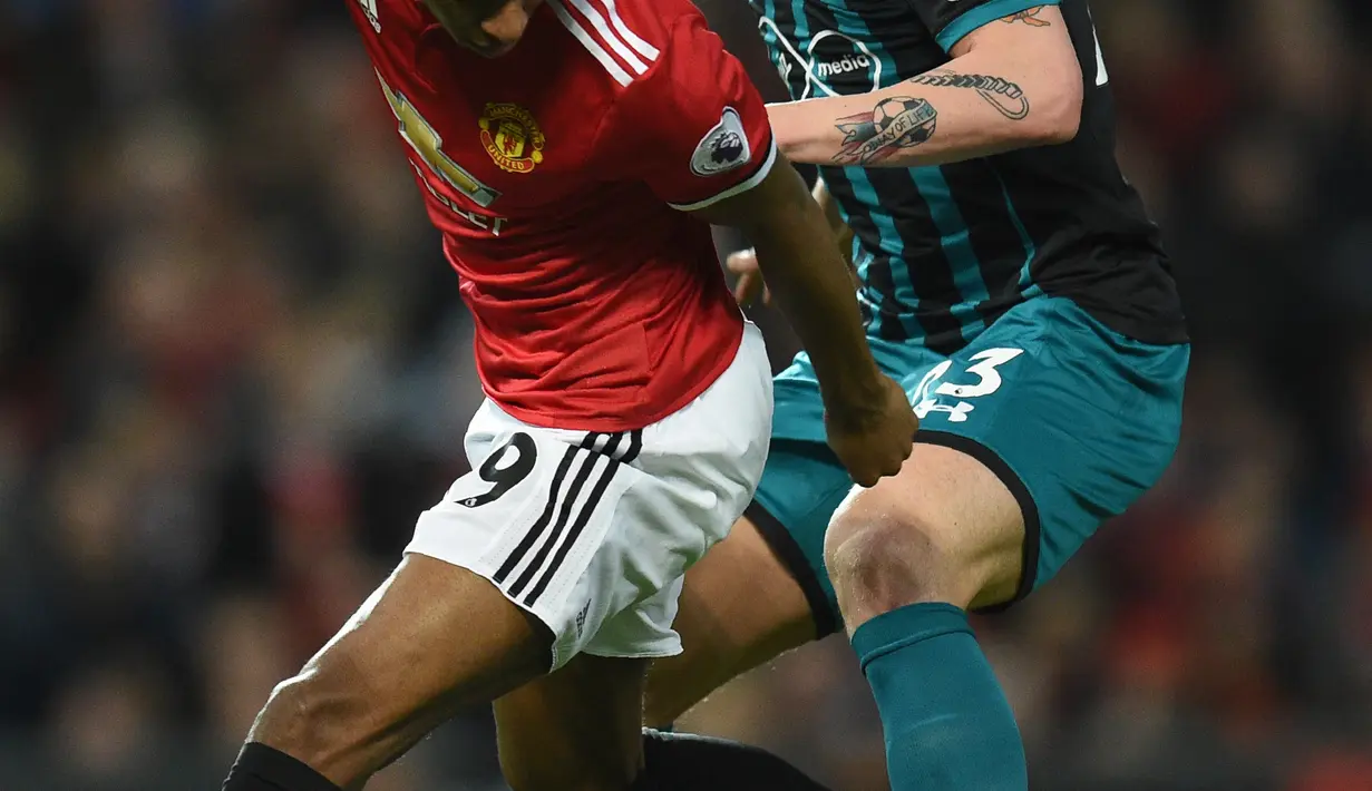 Pemain Manchester United, Marcus Rashford (kiri) berebut bola dengan pemain Southampton, Danish, Pierre-Emile Hojbjerg pada lanjutan Premier League di Old Trafford, Manchester, (30/12/2017). MU hanya bermain imbang 0-0.  (AFP/Oli Scarff)