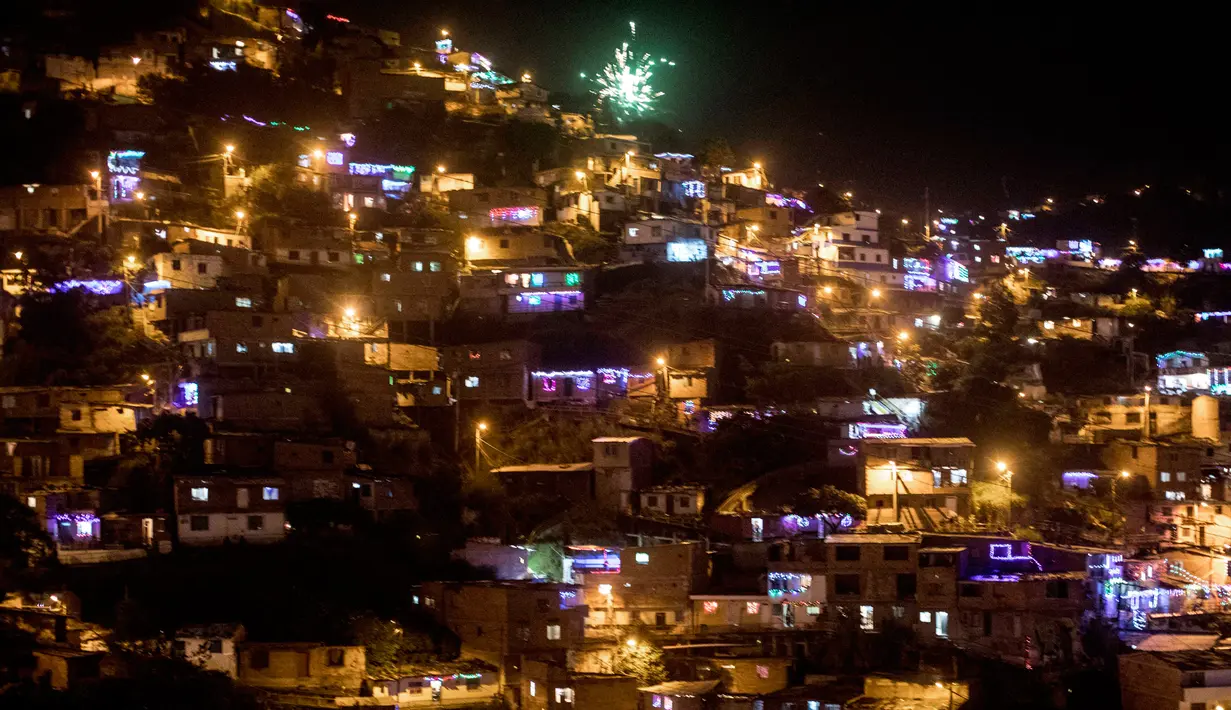 Pemandangan Comuna 13 selama perayaan Hari Lilin Kecil di Medellin, Kolombia (7/12). Warga juga mengunjungi pemakaman untuk menghiasi kuburan keluarga mereka yang tiada dengan bunga, lentera dan lilin. (AFP Photo/Luis Robayo)