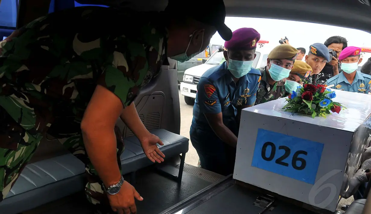 Tim SAR gabungan kembali menerima 12 jenazah korban pesawat AirAsia QZ8501 di Lanud TNI AL Juanda, Surabaya, Sabtu (3/1/2015). Jenazah bernomor peti 026 dimasukkan ke  ambulans untuk dibawa menuju RS Bhayangkara POlda Jatim. (Liputan6.com/Johan Tallo)