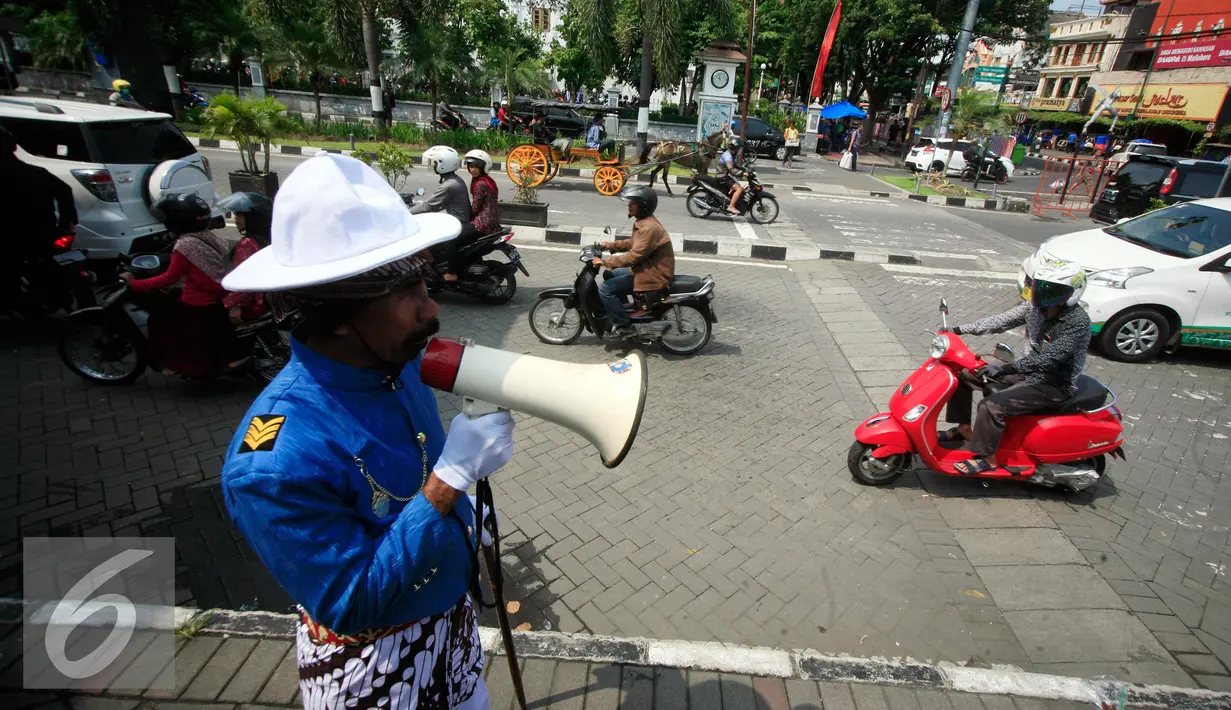 Petugas dari UPT Malioboro dengan mengenakan pakaian tradisional mengatur pengendara sepeda motor yang akan parkir di taman parkir Abu Bakar Ali Yogyakarta, (5/4). (Liputan6.com/Boy Harjanto)