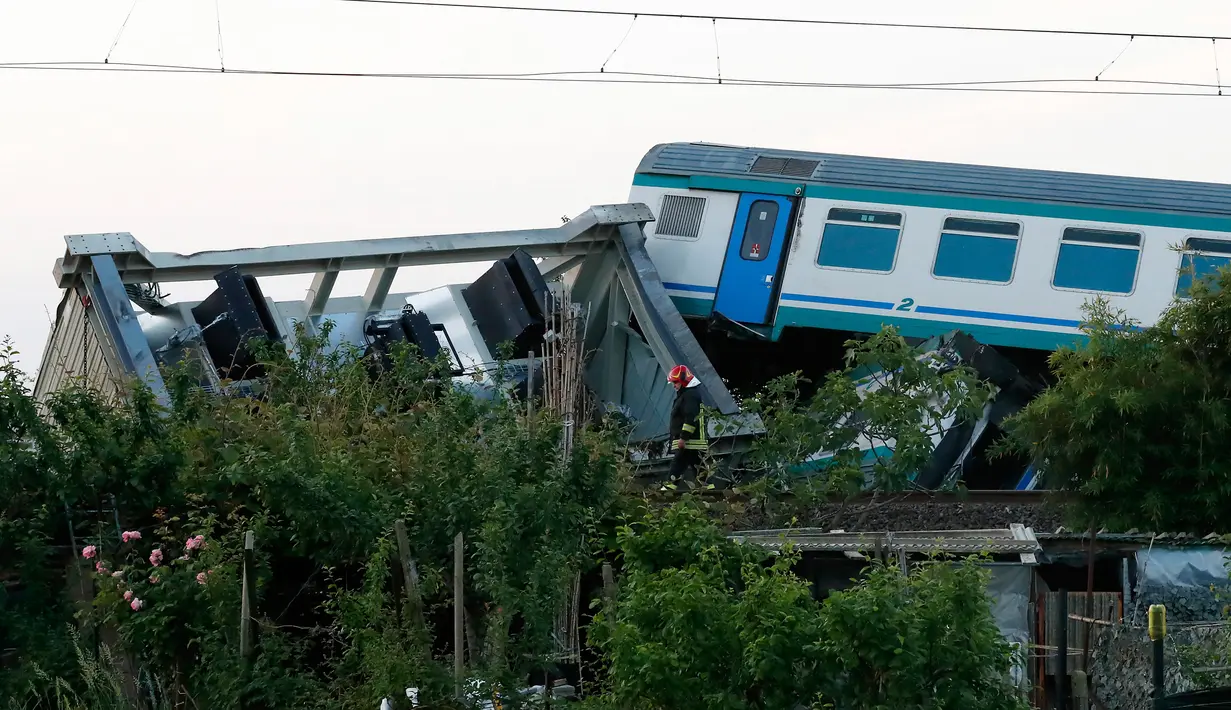 Petugas pemadam memeriksa kondisi kereta api yang menabrak sebuah truk di dekat wilayah Turin, Italia, Kamis (24/5). Berdasarkan laporan, kereta ini tengah melakukan perjalanan dari Turin dengan tujuan ke Ivrea. (AP/Antonio Calanni)