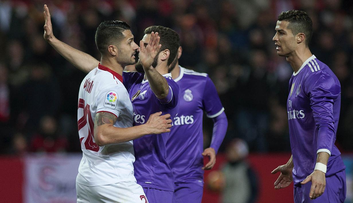 Gelandang Sevilla, Vitolo, berdebat dengan bintang Real Madrid, Cristiano Ronaldo. Pada laga yang berjalan keras ini wasit mengeluarkan tiga kartu kuning untuk Sevilla dan satu untuk Madrid. (AFP/Jorge Guerrero)