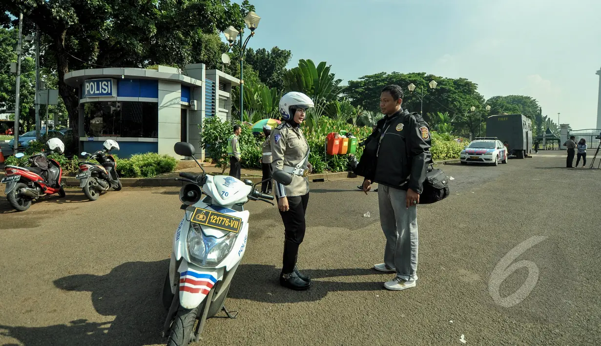 Polisi wanita (polwan) mulai mengenakan jilbab saat bertugas di pelataran Silang Monas, Jakarta, Jumat (27/3/2015). Polwan di seluruh Indonesia akhirnya diperbolehkan mengenakan jilbab. (Liputan6.com/Faizal Fanani)