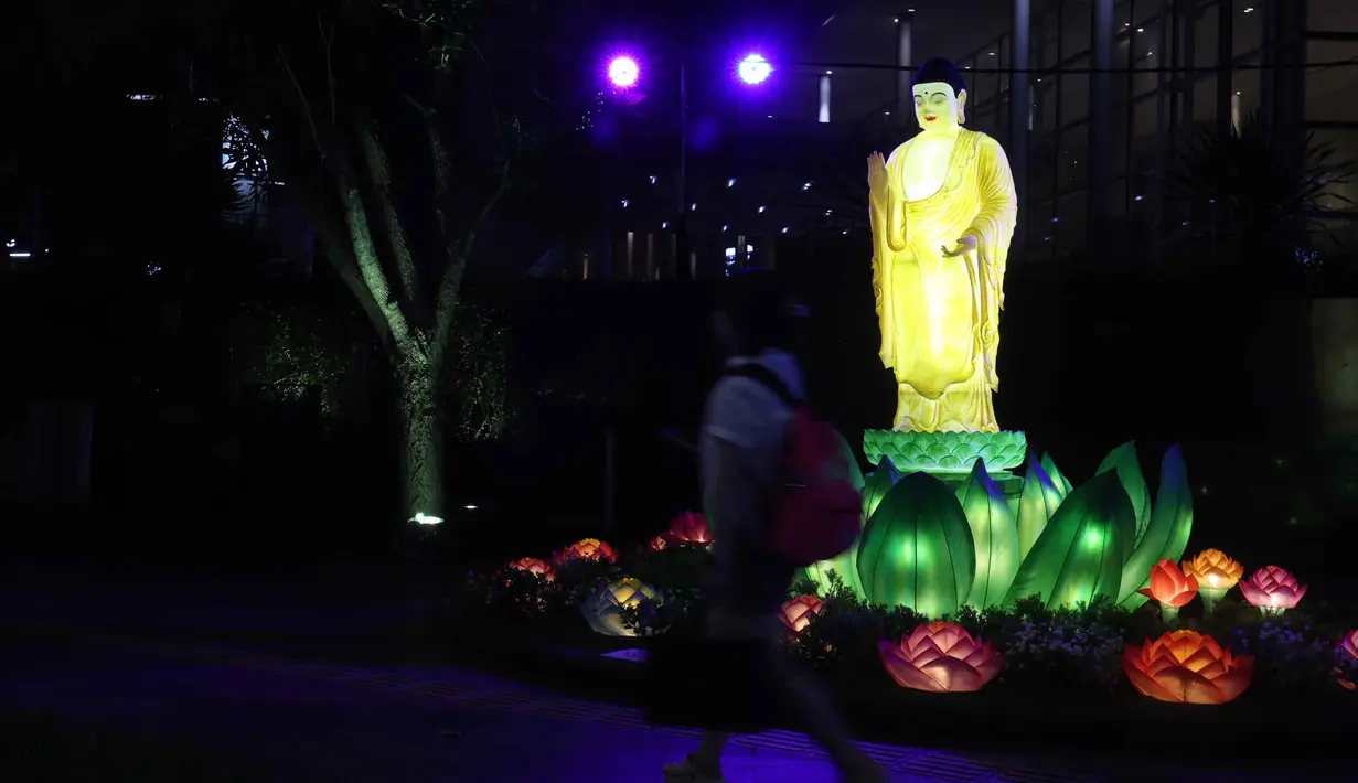 Warga berjalan di dekat ornamen lampu hias saat llumination of Jakarta: Glow of Peace di kawasan Bundaran Hotel Indonesia, Jakarta, Kamis (28/5/2026). (Kapanlagi.com/Budy Santoso)