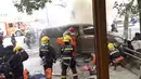 Pemadam kebakaran memadamkan api dari sebuah van yang menabrak para pejalan kaki di trotoar daerah sibuk di Shanghai, China, Jumat (2/2). Namun, tidak dijelaskan apakah kebakaran berlangsung sebelum atau saat insiden terjadi. (AP Photo)