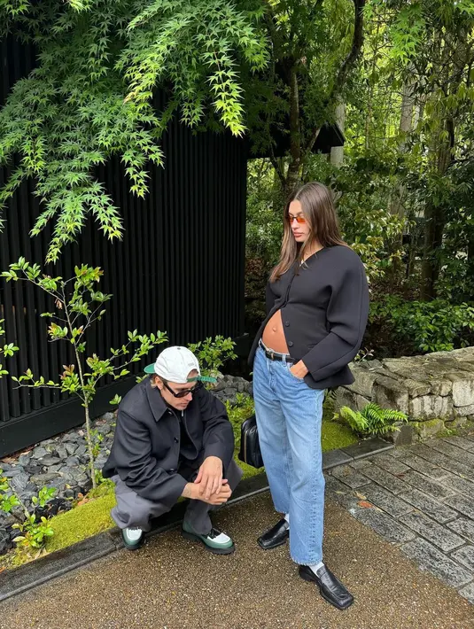 Sang calon ayah mengenakan blazer besar dan celana panjang serasi yang dipadukan dengan sepatu pantofel. Sementara Hailey dengan bangga menampilkan baby bump-nya yang semakin membesar dalam jaket pas yang tidak dikancingkan di sekitar perutnya. [@haileybieber/@justinbieber]