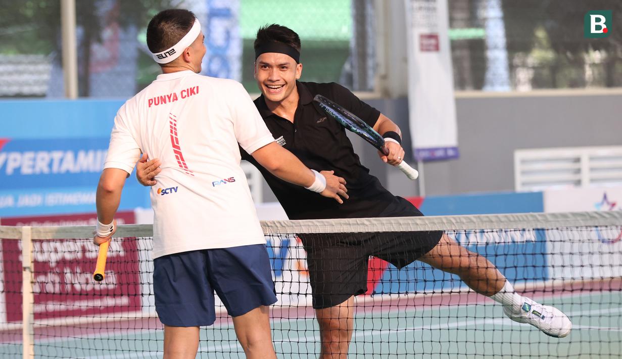 <p>Artis yang sekaligus atlet MMA, Randy Pangalila (kanan), memberikan selamat kepada rekan sesama artis, Rezky Aditya (kiri), dalam pertandingan tenis tunggal putra Turnamen Olahraga Selebriti Indonesia yang berlangsung di Gelanggang Olahraga UNJ, Rawamangun, Jakarta Timur, Sabtu (29/7/2023). Pertandingan kali ini berhasil dimenangkan oleh Rezky Aditya dengan dua set langsung (1-6 - 1-6). (Bola.com/Abdul Aziz)</p>