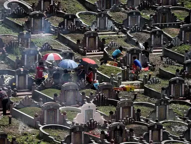 Etnis China Malaysia mengunjungi makam leluhur mereka pada festival tahunan Qingming (Cheng Beng) di Kuala Lumpur, Minggu (3/4). Festival itu merupakan hari ziarah kubur ditandai dengan mengunjungi dan membersihkan kuburan leluhur. (MANAN Vatsyayana/AFP)