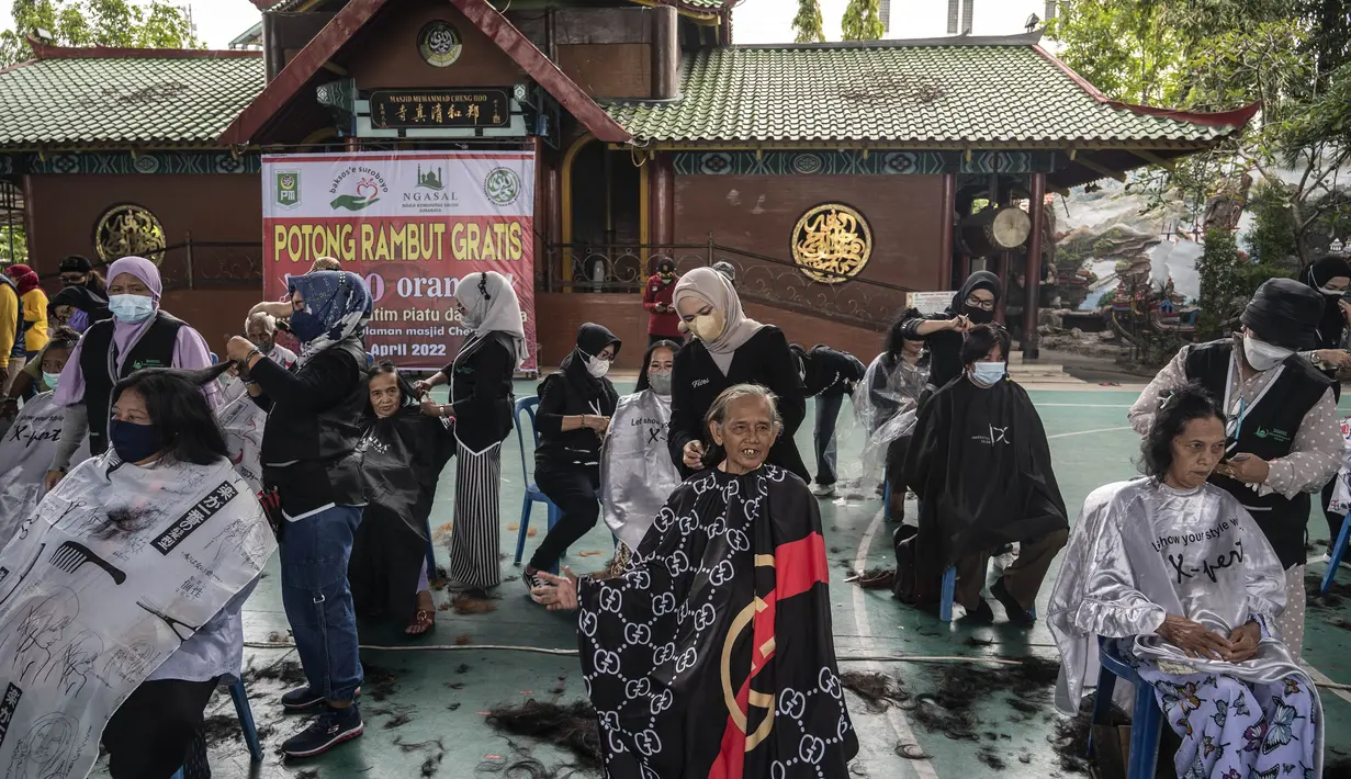 Penata rambut memberikan potongan rambut gratis sebagai bagian dari amal Muslim untuk yang membutuhkan saat umat Islam di seluruh dunia merayakan bulan suci Ramadhan di Muhammad Cheng Hoo di Surabaya (18/4/2022). (AFP/Juni Kriswanto)