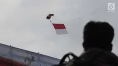 Prajurit Polairud melakukan aksi terjun payung sambil membentangkan bendera Merah Putih pada peringatan Hari Ulang Tahun (HUT) ke-67 Korps Polisi Air dan Udara di Lapangan Udara Pondok Cabe, Tangerang Selatan, Selasa (5/12). (Liputan6.com/Faizal Fanani)