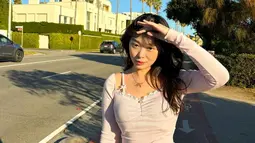 Saat berada di Melbourne, Australia, Livy memilih crop top lengan panjang berwarna pink muda dengan detail renda, dipadukan dengan celana putih. Paduan warna yang cerah ini menciptakan kesan segar dan stylish, memancarkan pesonanya sebagai fashionista muda. Dengan latar deretan pohon palem di jalan raya, Livy tampak effortless namun tetap mencuri perhatian. (Liputan6.com/IG/@livyrenata)