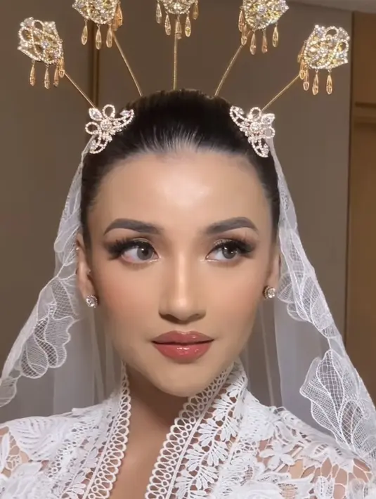 Sebelum mengenakan kebaya, saat sesi makeup, Tsania Marwa pun tampil mengenakan robe. Dihiasi dengan veil tulle putih yang indah. [@bennusorumba]