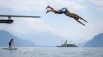 Seorang pria melompat ke Danau Jenewa di Saint Saphorin, Swiss barat saat gelombang panas melanda seluruh Eropa utara (31/7). Akibat gelombang panas suhu di beberapa bagian Swiss mencapai 35 Derajat. (AFP Photo/Fabrice Coffrini)