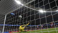 Sepakan pemain Atletico Madrid, Antoine Griezmann menembus pertahanan kiper Chelsea, Thibaut Courtois pada laga grup C Liga Champions di Wanda Metropolitano stadium, Madrid, Spanyol, (27/9/2017). Chelsea menang 2-1. (AP/Francisco Seco)