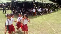 Sejumlah siswa melintas di sekolah tenda darurat di lokasi pengungsian bencana Gunung Merapi di keputren, Kemalang, Klaten, Selasa (2/11).(Antara) 