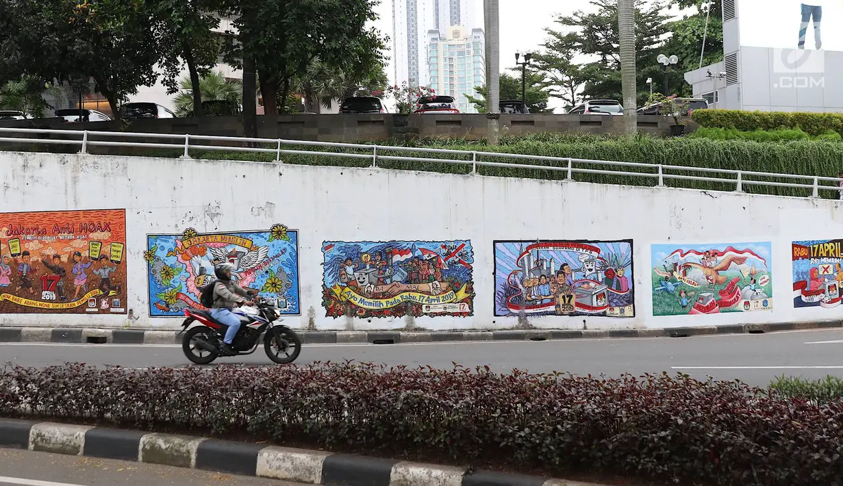 Kendaraan melintasi mural bertema Pemilu 2019 di kawasan Dukuh Atas, Jakarta, Senin (1/4). Mural-mural tersebut dibuat dalam rangka menyukseskan Pemilu yang akan berlangsung pada 17 April 2019 mendatang. (Liputan6.com/Immanuel Antonius)