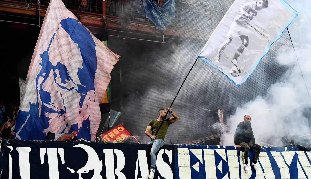 Aksi fans Napoli mengibarkan bendera saat mendukung timnya melawan Genoa pada lanjutan Serie A di Luigi Ferraris stadium, Genoa, (25/10/2017). Napoli menang 3–2. (AFP/Vincenzo Pinto)