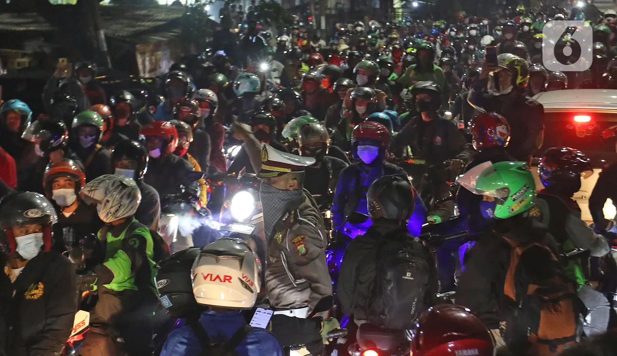 Petugas kepolisian saat menghalau pemudik yang lawan arus di Jalan Kedungwaringin, Kabupaten Bekasi, Jawa Barat, Minggu (9/5/2021). Pemudik memblokir jalan saat penyekatan di posko penyekatan mudik di Kedungwaringin. (Liputan6.com/Herman Zakharia)