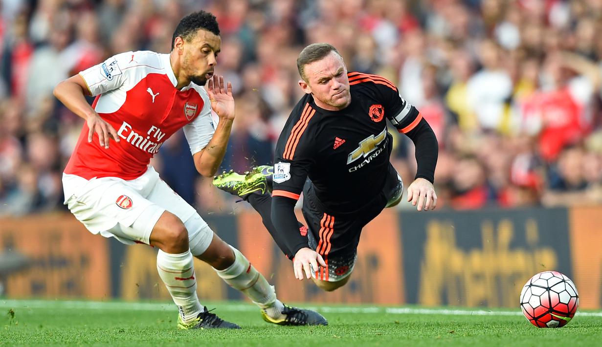 Pemain Manchester United Wayne Rooney berebut bola dengan pemain Arsenal Alexis Sanchez  pada Laga lanjutan Liga Premier Inggris di Emirates Stadium. Minggu (04/10/2015). Arsenal menang 3-0 atas MU.(Reuters / Dylan Martinez)