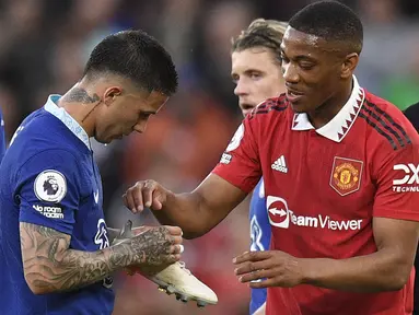 Pemain MU, Anthony Martial (kanan), mengambil sepatu miliknya dari tangan pemain Chelsea, Enzo Fernandez, dalam laga tunda pekan ke-32 Liga Inggris 2022/2023 yang berlangsung di Old Trafford, Jumat (26/5/2023). (AFP/Oli Scarff)