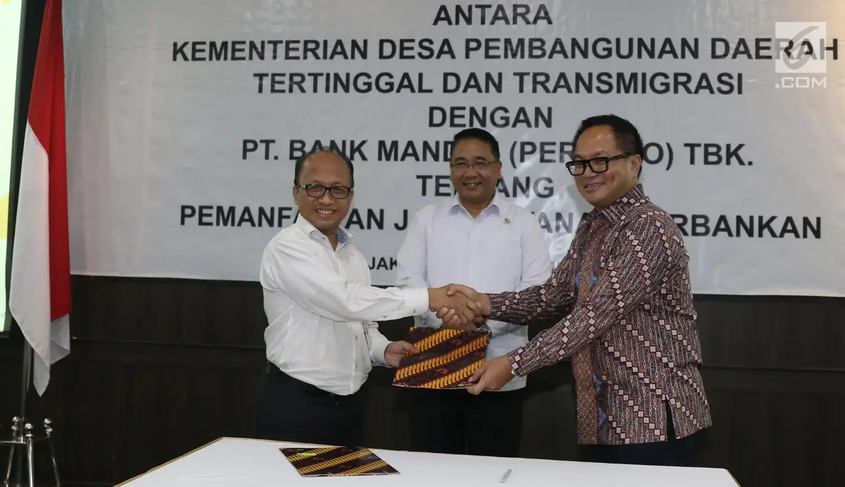 Mendes PDTT Eko Putro Sandjojo (tengah) menyaksikan Sekjen Kemendes PDTT Anwar Sanusi (kiri) dan Dirut Bank Mandiri Kartika Wirjoatmodjo (kanan) bertukar naskah MoU kerja sama di Kantor Kemendes PDTT, Jakarta, Senin (30/9/2019). (Liputan6.com/Angga Yuniar)
