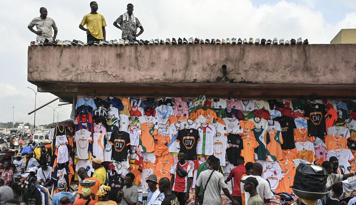 Kesibukan salah satu pasar di Abidjan, pusat kota Pantai Gading menjelang Piala Afrika 2023 pada Sabtu (06/01/2024) waktu setempat. Pasar tesebut terlihat dipenuhi dengan pernak-pernik Piala Afrika 2023 seperti jersey dan sepatu. (AFP/Issouf Sanogo)