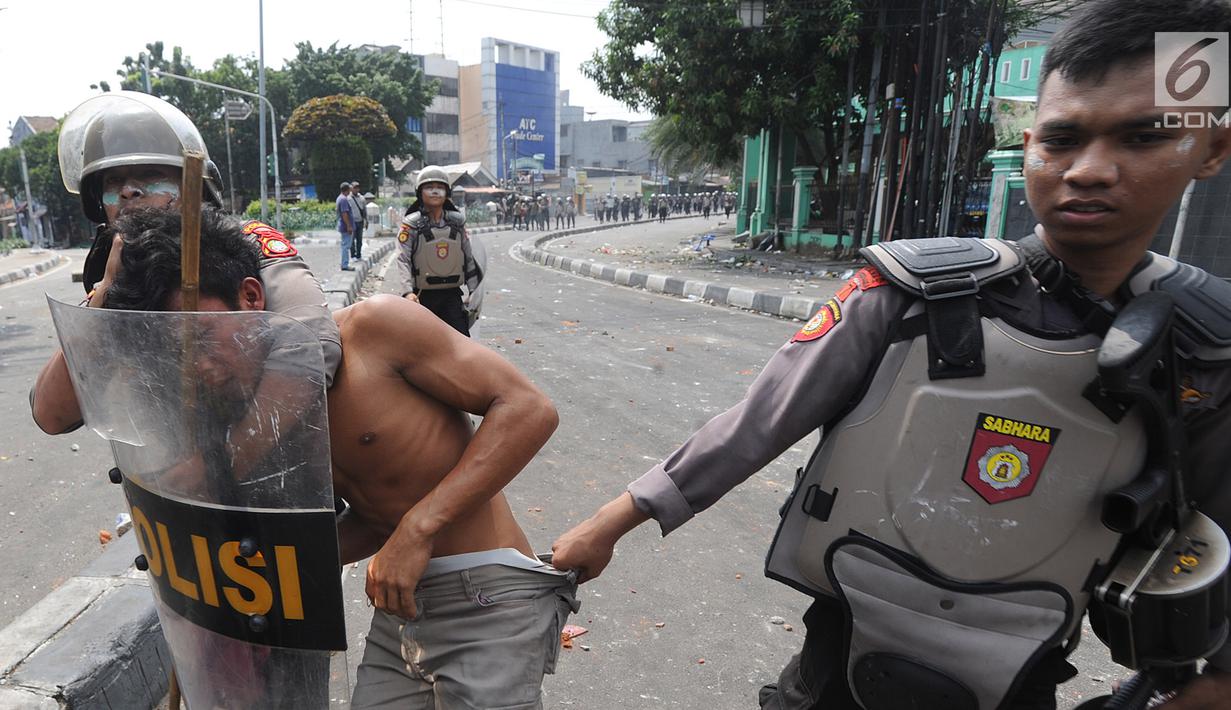 Anggota Sabhara Polri menangkap pengunjuk rasa saat bentrok  dengan massa aksi 22 Mei sebelum terjadi pembakaran bis milik Brimob di kawasan Tanah Abang,  Jakarta, Rabu (22/5/2019). (merdeka.com/Arie Basuki)