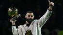 Pemain Real Madrid Karim Benzema berpose di lapangan dengan trofi Ballon d'Or miliknya pada babak pertama pertandingan sepak bola L1 Prancis antara Olympique Lyonnais (OL) dan OGC Nice di Stadion Groupama, Decines-Charpieu, Prancis, 11 November 2022. Karim Benzema memamerkan trofi Ballon d'Or kepada para fans Olympique Lyon yang notabenenya adalah kota kelahirannya. (OLIVIER CHASSIGNOLE/AFP)