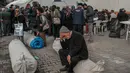Seorang pria duduk di atas tenda yang digulung di taman Yenimahalle Cemevi, milik anggota komunitas Alevi, Adiyaman, Turki, Minggu (19/2/2023). Gempa bumi berkekuatan 7,8 magnitudo melanda dekat Gaziantep, Turki, pada dini hari tanggal 6 Februari, diikuti oleh gempa susulan berkekuatan 7,5 magnitudo setelah tengah hari. Gempa bumi tersebut menyebabkan kehancuran yang meluas di Turki Selatan dan Suriah Utara dan telah menewaskan lebih dari 40.000 orang. (BULENT KILIC/AFP)