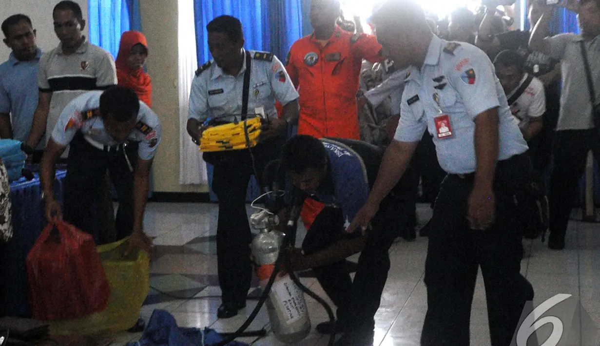 Tim SAR mengumpulkan sejumlah barang temuan yang diduga milik penumpang pesawat AirAsia QZ8501, Pangkalan Bun, Kalteng, Selasa (30/12/2014). (Liputan6.com/Miftahul Hayat)