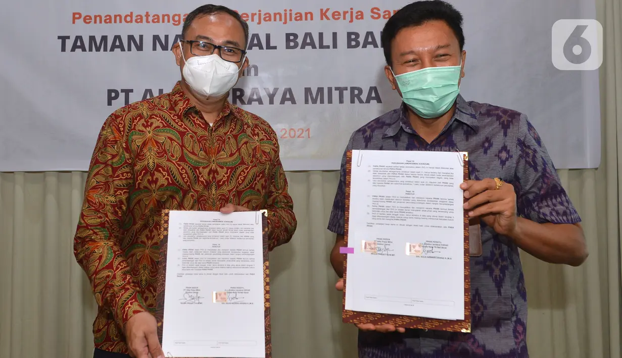 (ki-ka) Dirut PT Alita Praya Mitra Teguh Prasetya dan Kepala Balai Taman Nasional Bali Barat Dirjen KSDA dan Ekosistem Kementerian LHK,  Agus Ngurah Krisna menunjukkan naskah kerja sama pembangunan sarana komunikasi jaringan kabel serat optik di Bali, Kamis (27/10/2021). (Liputan6.com/HO/Alwi)
