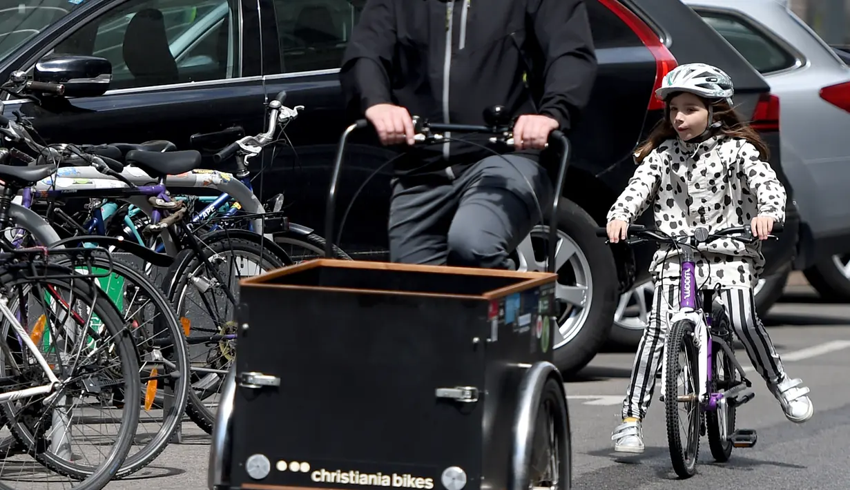 Seorang anak mengendarai sepeda di sebuah jalan di Wina, Austria, (13/5/2020). Menurut Transport Club Austrian, semakin banyak warga Wina memilih bepergian menggunakan sepeda selama pandemi. (Xinhua/Guo Chen)