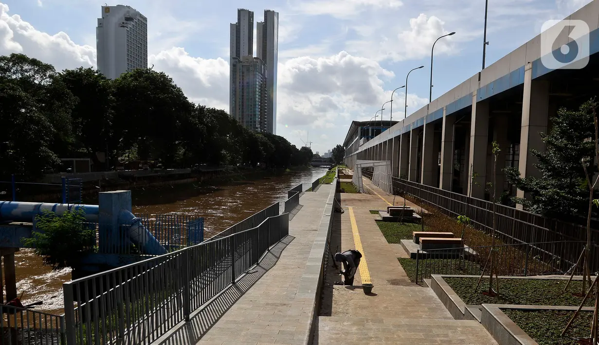 Pekerja menyelesaikan pembangunan ruang terbuka hijau dalam program naturalisasi di Kanal Banjir Barat (KBB) Shangrilla-Karet, Jakarta, Jumat (21/2/2020). Pembangunan prasarana kali/sungai dan kelengkapannya di KBB segmen Karet-Sudirman ini menelan anggaran Rp 12,7 miliar. (Liputan6.com/Johan Tallo)