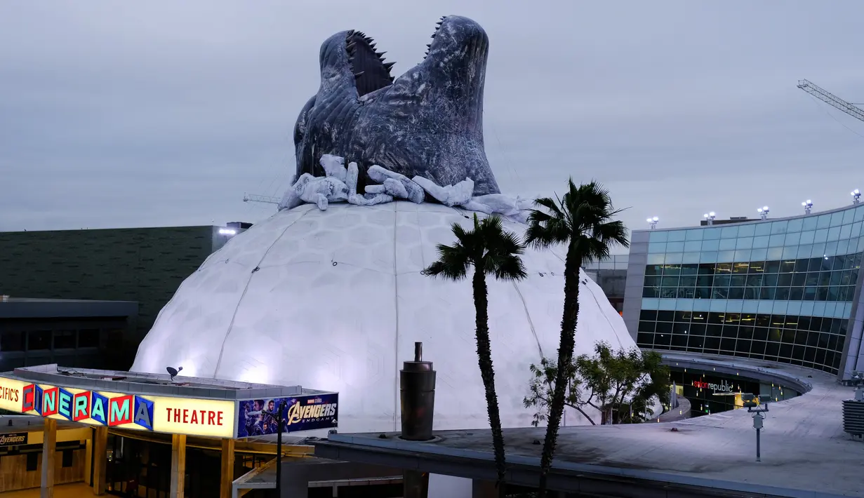 Godzilla raksasa menghiasi atap bioskop Cinerama Dome yang berlokasi di Hollywood, California, AS pada 20 Mei 2019. Hinggapnya godzilla raksasa untuk menyambut sekuel Godzilla: King of the Monsters yang akan dirilis pada 31 Mei 2019. (Photo by Chris Delmas / AFP)