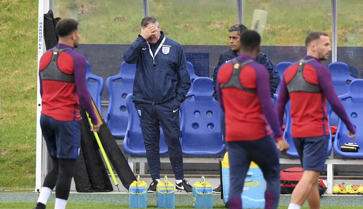 Pelatih Timnas Inggris, Sam Allardyce (tengah) saat enutup wajahnya pada sesi latihan timnas Inggris di St George's Park dekat Burton-Upon-Trent, (3/9/2016). (AFP/Anthony Devlin) 