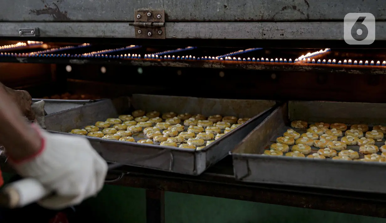 Pekerja saat memanggang kue kering di sebuah industri rumahan di Kawasan Kwitang, Jakarta, Jumat (30/4/2021). Tahun ini produksi kue kering menjelang lebaran mulai meningkat namun masih mengalami penurunan produksi hingga separuhnya dibandingkan dengan sebelum pandemi. (Liputan6.com/Faizal Fanani)