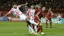 Pemain Kroasia Bruno Petkovic (kiri) berebut bola dengan pemain Armenia Styopa Mkrtchyan (kanan) pada pertandingan sepak bola Kualifikasi Euro 2024 di Stadion Republik Vazgen Sargsyan, Yerevan, Armenia, Senin (11/9/2023). (KAREN MINASYAN/AFP)