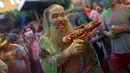 Seorang pria dengan tubuh penuh cat memegang pistol plastik saat mengikuti Festival Monsoon Holi di Madrid, Spanyol (5/8). Festival yang menjadi salah satu tradisi di India dan Nepal ini, kini menjadi trend di sejumlah negara. (AP Photo/Francisco Seco)