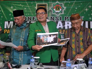 Wakil Ketua Umum PPP Emron Pangkapi (tengah) memperlihatkan sebuah gambar saat menggelar konferensi pers terkait pelaksanaan Muktamar Islah PPP, Jakarta, Kamis (31/3/2016). (Liputan6.com/ JohanTallo)