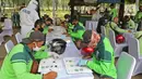 Petugas penggali makam mengikuti ujian teori saat  pelayanan penerbitan SIM baru di TPU Pondok Ranggon, Jakarta, Kamis (2/7/2020). Direktorat Lalu Lintas Polda Metro Jaya memberikan pelayanan penerbitan SIM baru gratis bagi penggali makam yang menangani korban Covid-19.(Liputan6.com/Herman Zakharia)