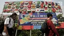 Warga melintas di depan instalasi berupa bendera negara-negara peserta Asian Games 2018, Jakarta, (15/7). Sambut Asian Games, Kelurahan Bungur mempercantik kawasan di pinggir Kali Sunter dengan mengecat warna-warni tembok. (Merdeka.com/Iqbal S. Nugroho)