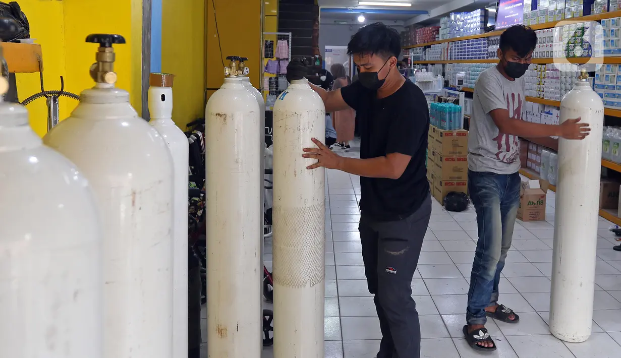 Pekerja memindahkan tabung oksigen di Fauzi Medical, Matraman, Jakarta Timur, Kamis (22/7/2021). Sebagai bentuk kepedulian terhadap sesama di tengah pandemi COVID-19, agen isi ulang oksigen tersebut menerapkan sistem pembayaran secara sukarela bagi warga. (Liputan6.com/Herman Zakharia)