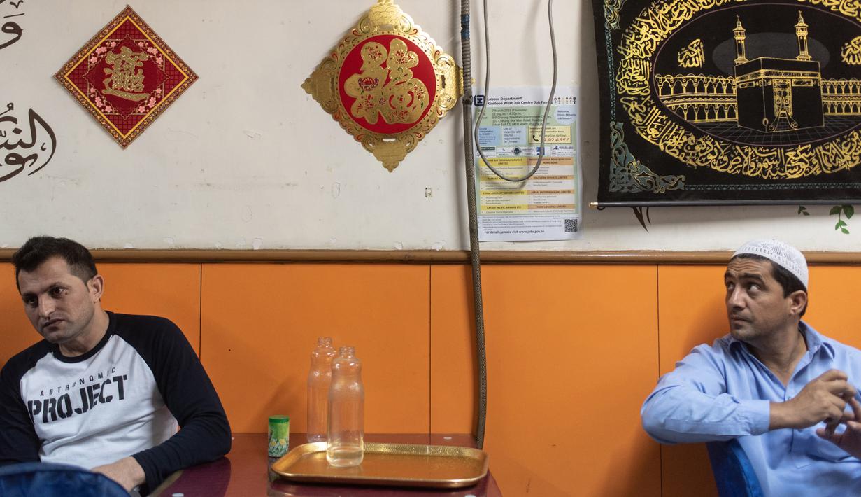 Para imigran Pakistan duduk usai menyantap makanan sahur untuk berpuasa di dalam sebuah restoran di distrik Kwai Chung, Hong Kong (25/5/2019). Luas wilayah kota ini 9,93 km². Area dalam Kwai Chung meliputi: Kwai Fong, Kwai Hing, Lai King, Tai Wo Hau. (AFP Photo/Philip Fong)