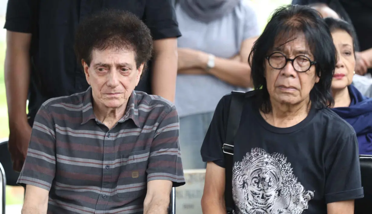 Semasa hidupnya, Donny Fattah dikenal sebagai sosok sentral dalam sejarah musik rock Indonesia. Tampak dalam foto, ekspresi vokalis grup band God Bless, Ahmad Albar (tengah) bersama Ian Antono (kanan) menyaksikan prosesi pemakaman jenazah Donny Fattah di Tempat Pemakaman Umum (TPU) Kampung Kandang, Jagakarsa, Jakarta Selatan, Sabtu (7/3/2026). (Kapanlagi.com/Budy Santoso)