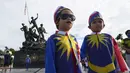 Dua anak laki-laki yang mengenakan kostum bendera nasional Malaysia berfoto di depan Monumen Nasional saat perayaan Hari Nasional ke-64 untuk memperingati kemerdekaan dari penjajahan Inggris di Kuala Lumpur, Malaysia, Selasa (31/8/2021). (AP Photo/Vincent Thian)