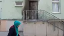 Seorang wanita berhijab melintas di pintu Masjid Fatih Camii yang rusak akibat serangan bom di Dresden, Jerman Timur, Senin (26/9) malam. Tidak ada korban namun terdapat kerusakan di bangunan masjid akibat getaran ledakan itu. (SEBASTIAN KAHNERT/DPA/AFP)