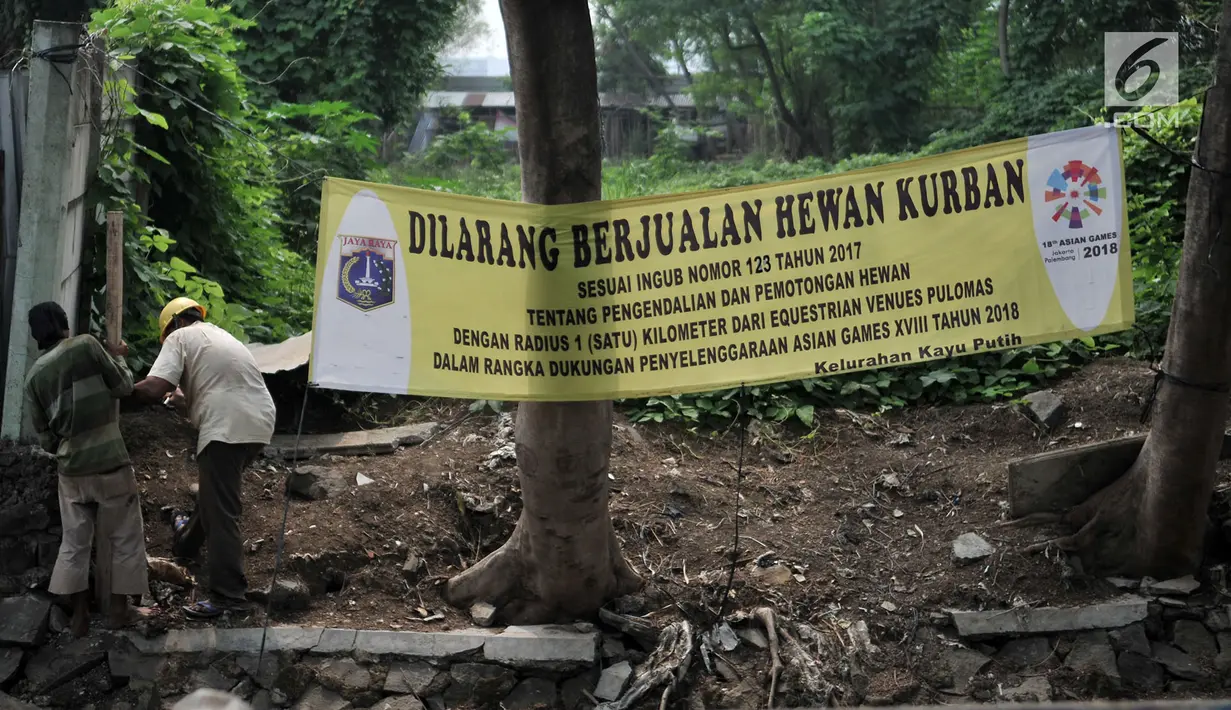 Pekerja beraktivitas dekat spanduk larangan di kawasan Pulomas, Jakarta, Rabu (4/7). Pemprov DKI melalui Sudin Ketahanan Pangan, Kelautan dan Pertanian (KPKP) memasang spanduk larangan berjualan hewan kurban jelang Idul Adha (Merdeka.com/Iqbal S. Nugroho)