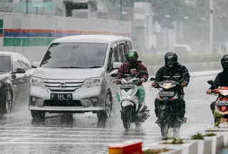 Pengendara motor menggunakan jas hujan saat hujan deras mengguyur kawasan Jalan Thamrin, Jakarta, Selasa (31/5/2022). Potensi cuaca ekstrem di sejumlah wilayah di Indonesia pada hari ini dipengaruhi oleh kemunculan bibit siklon tropis 92S di Samudera Hindia selatan Jawa Barat. (Liputan6.com/Faizal Fanani)