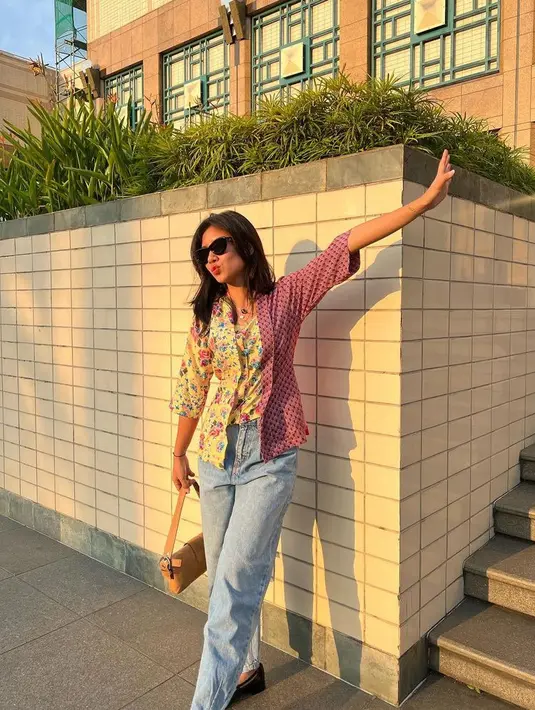 Shenina Cinnamon tampil dengan kebaya kutu baru warna colorful. Dipadukan celana denim panjang sambil membawa mini bag coklat. [@sheninacinnamon]